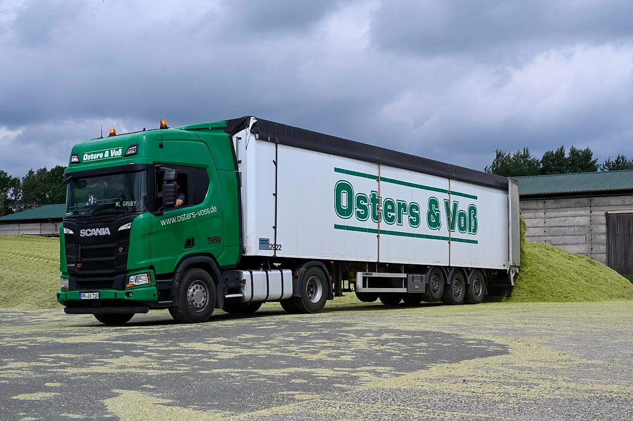 Grüner Scania-Sattelzug von Osters & Voß Logistics mit beschriftetem Auflieger auf dem Silogelände bei Perleberg