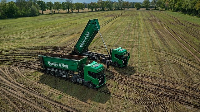Drohnenaufnahme: zwei Kipper von Osters & Voß Logistics auf dem Feld